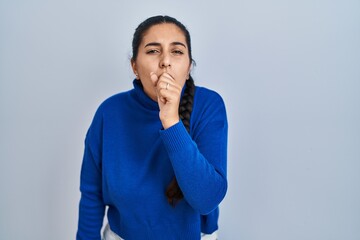 Poster - Young hispanic woman standing over isolated background feeling unwell and coughing as symptom for cold or bronchitis. health care concept.