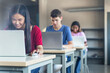 © EFStock - Diverse multi ethnic teenager college students studying with laptops at High School classroom