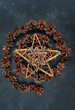 Pine cones, amulet with deer and pentacle star of tree branches on dark abstract background.  Witchcraft Esoteric Ritual. symbol of Christmas, Yule, Winter Solstice wiccan holiday. top view.