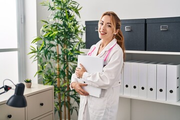 Sticker - Young woman doctor smiling confident holding binder at clinic