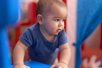 Wall Mural - Adorable chinese toddler leaning on stool standing at kindergarten