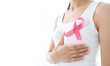 © Ton Photographer4289 - Pink ribbon on the chest of a woman in a white t-shirt. Symbol of breast cancer awareness campaign. Healthcare concept