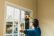 Worker use scraper cleaning window before installing tinting window film.