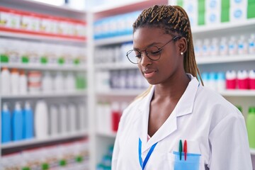 Canvas Print - African american woman pharmacist standing with serious expression at pharmacy