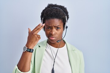 Poster - African american woman wearing call center agent headset shooting and killing oneself pointing hand and fingers to head like gun, suicide gesture.