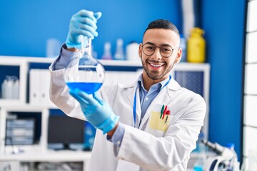 Sticker - African american man scientist smiling confident holding test tube at laboratory