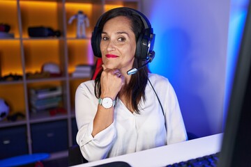 Sticker - Middle age brunette woman playing video games smiling looking confident at the camera with crossed arms and hand on chin. thinking positive.