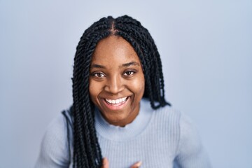 Wall Mural - African american woman standing over blue background smiling and laughing hard out loud because funny crazy joke with hands on body.