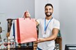 © Krakenimages.com - Young arab man shopkeeper holding shopping bags working at clothing store