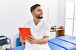 © Krakenimages.com - Young arab man wearing physiotherapist uniform using touchpad at clinic