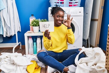 Poster - Beautiful black woman doing laundry asking for help doing ok sign with fingers, smiling friendly gesturing excellent symbol