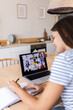 © Xavier Lorenzo - Vertical shot of young businesswoman working remotely on laptop having a video call with multiracial team employees working from home office - Virtual meeting conference