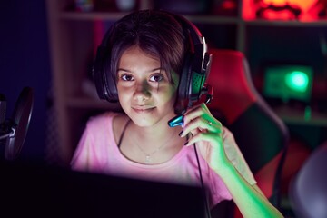 Sticker - Adorable hispanic girl streamer playing video game using computer at gaming room