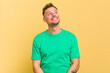 © Asier - Young caucasian handsome man isolated on yellow background relaxed and happy laughing, neck stretched showing teeth.