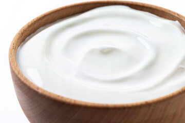 Wall Mural - Greek yogurt in wooden bowl isolated on white background. Creamy natural yogurt