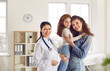 © Studio Romantic - Family doctor. Portrait of friendly young female pediatrician with little girl and her mother in medical office. Joyful woman and her daughter are satisfied with services of pediatrician in clinic.