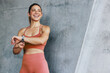 © Jacob Lund - Happy female athlete wearing sports wear and checking her pulse rate with smartwatch while outdoors exercising