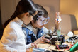 © KAMPUS - Concentrated boy in protective glasses using screwdriver to fix elements in new electronic device. Girl helping him, giving advice. Electronics, hobby concept