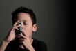 © herlanzer - child with flu with inhaler respiratory puff on grey background with people stock photo