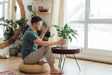 middle age man taking care of plants at home. concept of home gardening.