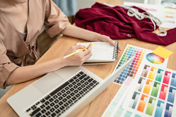 Young atelier or tailor making cloth on a studio table, Fashion designer.