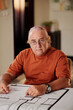 © DragonImages - Senior Man Checking Constructing Plan