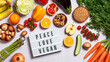 © Maria Shchipakina - Lightbox with quote Peace, Love, Vegan on table with raw vegan foods