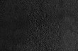 © serhiibobyk - Close up of dark grey, grainy surface for modern, unusual background design. Rough texture of black covering backdrop. Concept of textures and background.