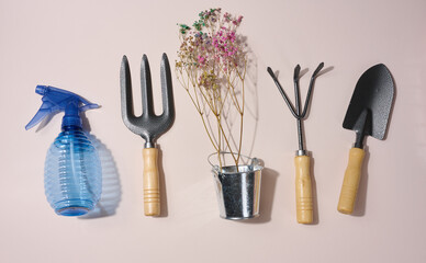 Wall Mural - Garden tools, shovel, rake and fork on a beige background, top view.