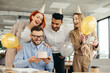 © dsheremeta - Young man is going to blow candles on cake and make a wish while celebrating birthday with colleagues. Colleagues celebrating a birthday in the office