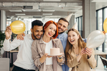 Business woman celebrating birthday and doing a party with colleagues in her office.