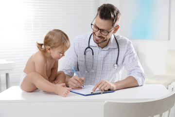 Wall Mural - Pediatrician examining cute little baby in clinic