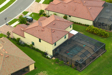 Wall Mural - Aerial view of expensive modern house with outside swimming pool covered with mosquito mesh on metal frame for insect protection in Florida closed living club