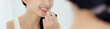 © NT_studio - Beautiful young asian woman applying lipstick red on mouth, beauty girl looking facial at mirror for makeup cosmetic with lips elegance, make up with sexy of female, skin care and health concept.
