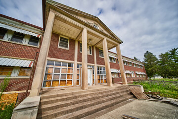 Wall Mural - Abandoned hospital in midwest America entrance exterior with huge stone pillars and steps