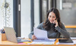 © David - Cheerful business Asian woman freelancer making telephone call share good news about project working in office workplace, business finance concept.