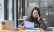 © David - Cheerful business Asian woman freelancer making telephone call share good news about project working in office workplace, business finance concept.