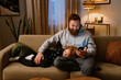 © Drobot Dean - Smiling father using smartphone while resting with his son on couch
