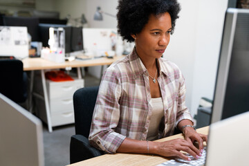 Concentrated black businesswoman employee worker analyzing online sales statistics data on computer