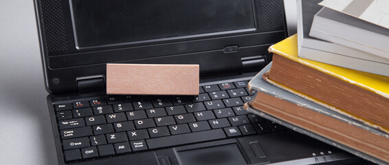 Wall Mural - Books and wooden cube on the laptop keyboard.