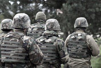 Wall Mural - Soldiers with assault rifles from the back.