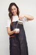 © Martin Villadsen - Professional barista woman serving a cup of coffee and pouring milk. Isolated on white background.
