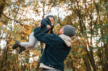 Wall Mural - Dad holding his son in the hands. Father and young son is together outdoors at daytime