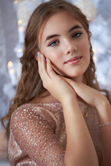 Poster - caucasian beautiful girl with long hair in a shiny dress on the background of the christmas tree