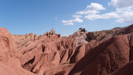 Poster - Tourists walk around Fairytale canyon or Skazka Canyon, Natural park of colorful rocks near Issyk-Kul lake, Kyrgyzstan.