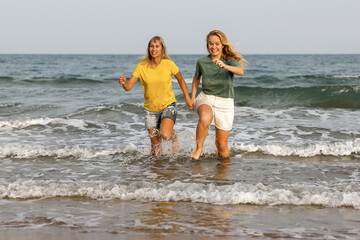 girlfriends walk and have fun at the sea, family vacation at sea