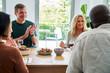 © PhotoAlto - Two mature diverse couples gathered at the table having a good time