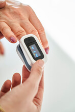 Woman measuring oxygen saturation with an oximeter