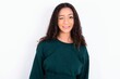 © Jihan - teen girl wearing knitted green sweater over white background blinking eyes with pleasure having happy expression. Facial expressions and people emotions concept.