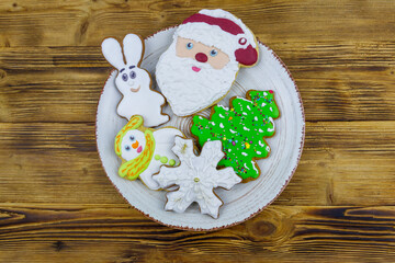 Wall Mural - Christmas gingerbread cookies in a plate on a wooden table. Top view